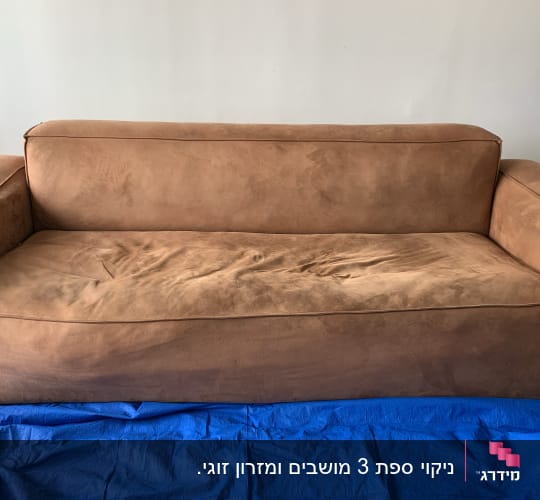 ספה חומה עם כיסוי כחול על הרצפה